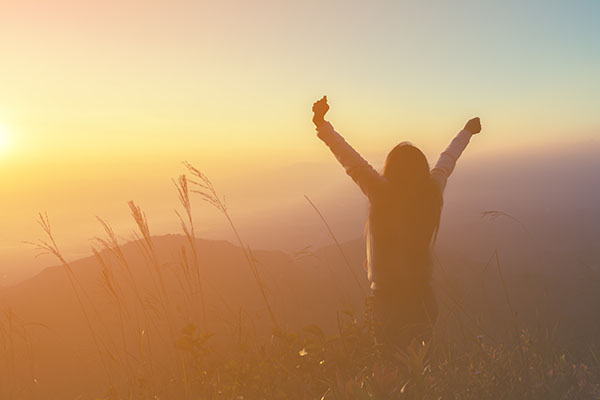 Relaxed woman enjoying a sunrise, completely stress free.